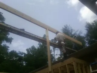 Carpenter setting a ridge beam over a new addition frame — Ice Dam Removal by Roofing Brothers in Pacoima