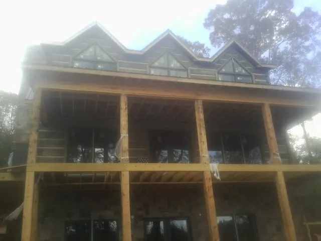 Dormers and porch framing on a large log home under construction — Roof Coating work by our crew in Pacoima